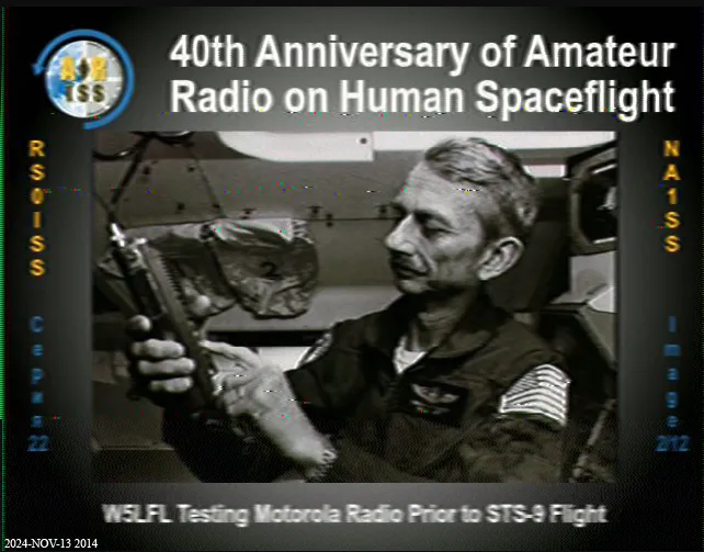 Black-and-white SSTV reception showing Owen Garriott testing a Motorola radio before the STS-9 mission.