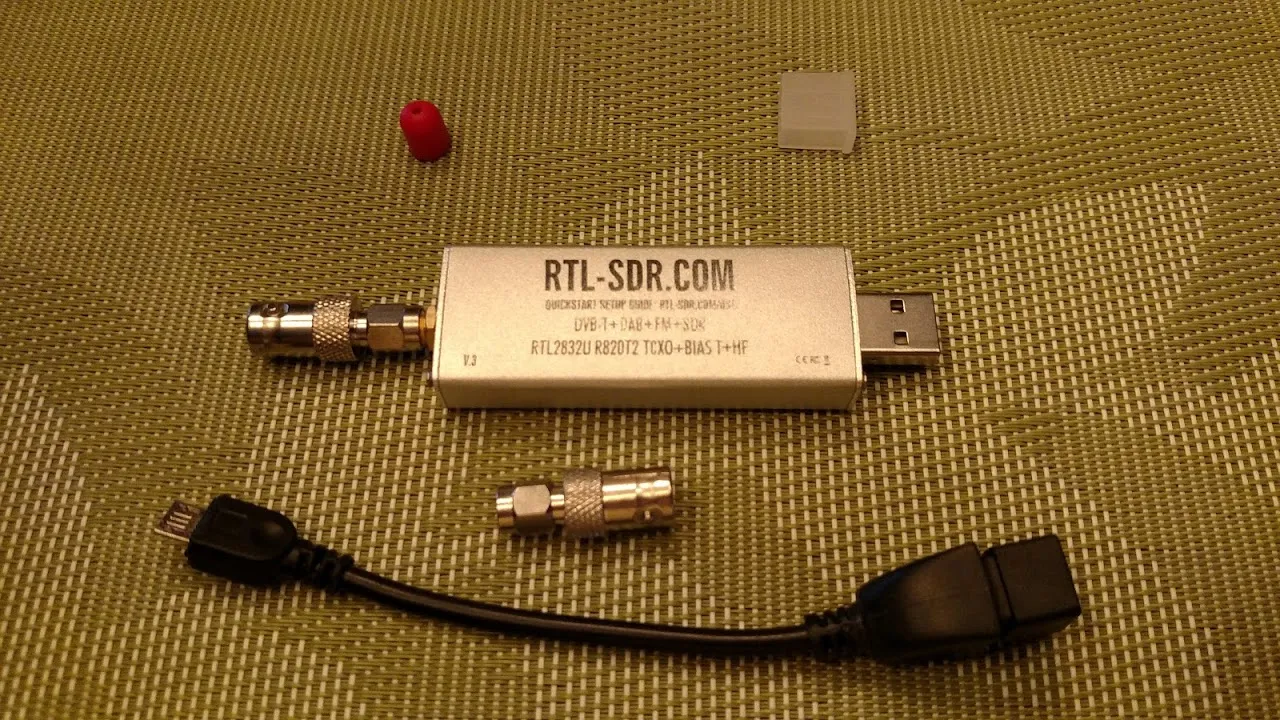 An RTL-SDR Blog V3 USB software-defined radio receiver with its SMA connector and adapters.