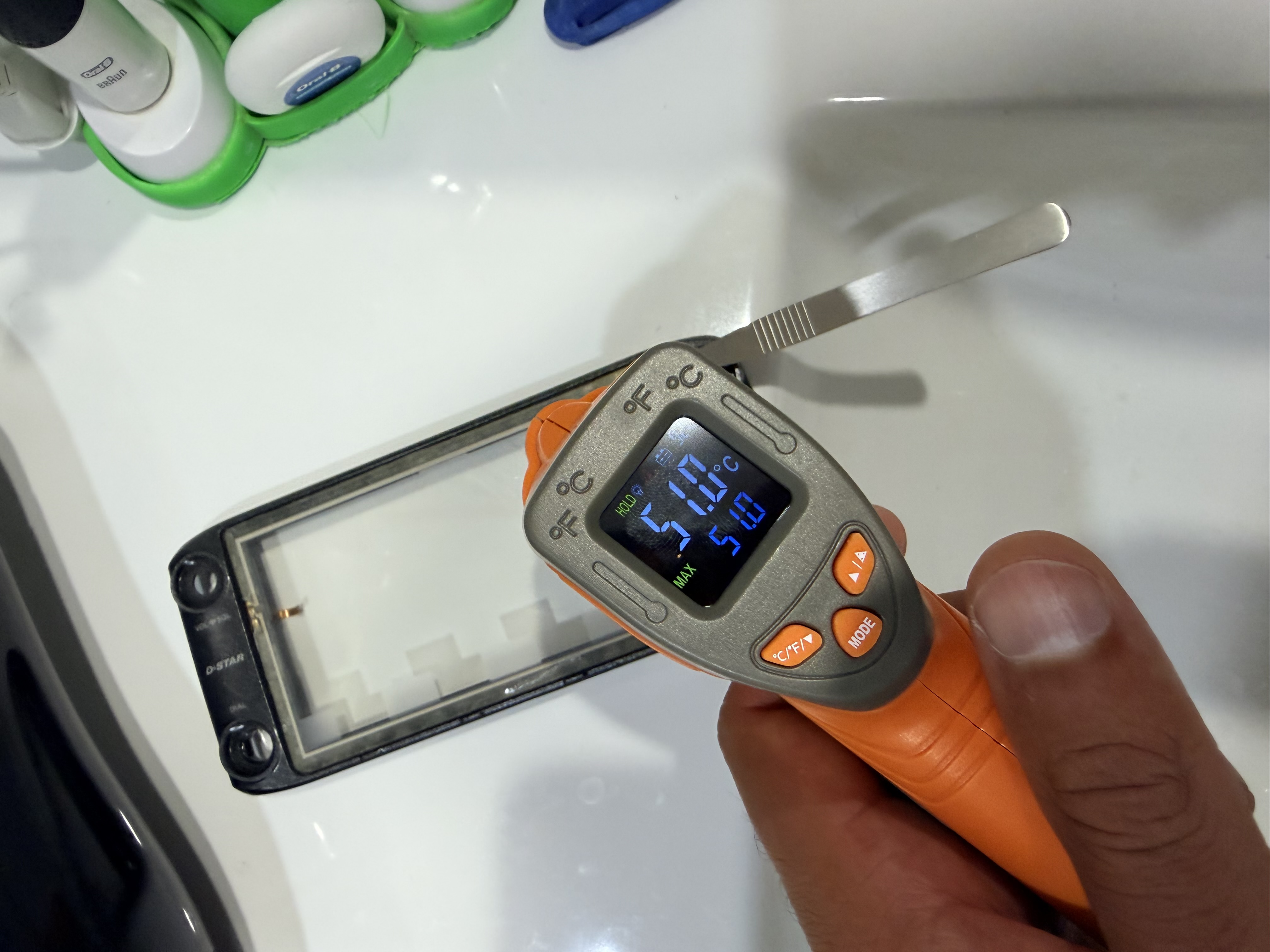 Infrared thermometer showing the warmed front assembly temperature during adhesive softening.